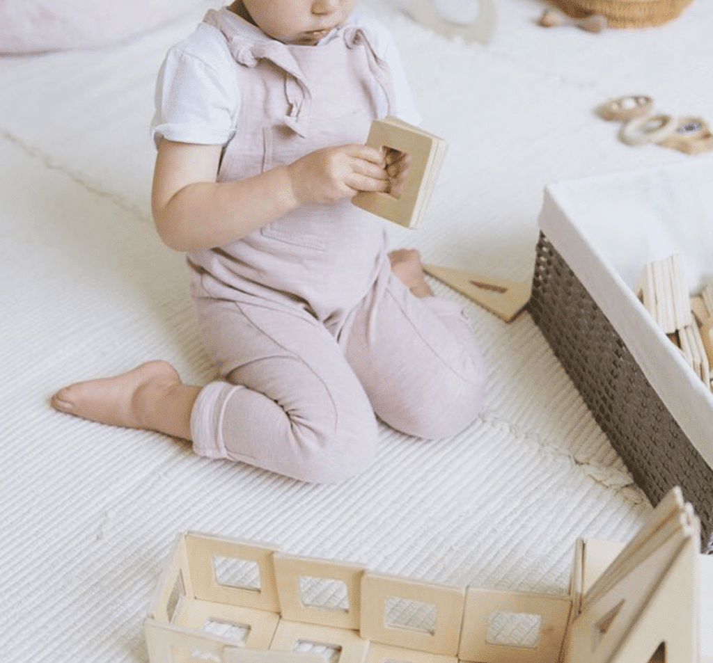 Three year old sitting in a W-sitting position while playing with blocks