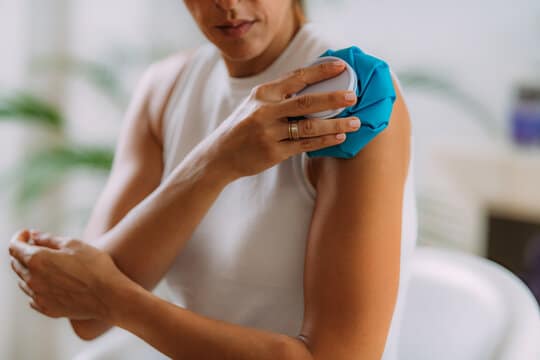 Woman icing her sore shoulder